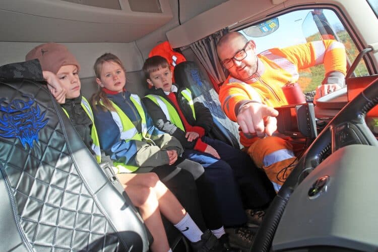 Longcliffe driver Ash Raven shows Cromford Primary School students safety technology in his lorry cab. Image/Longcliffe